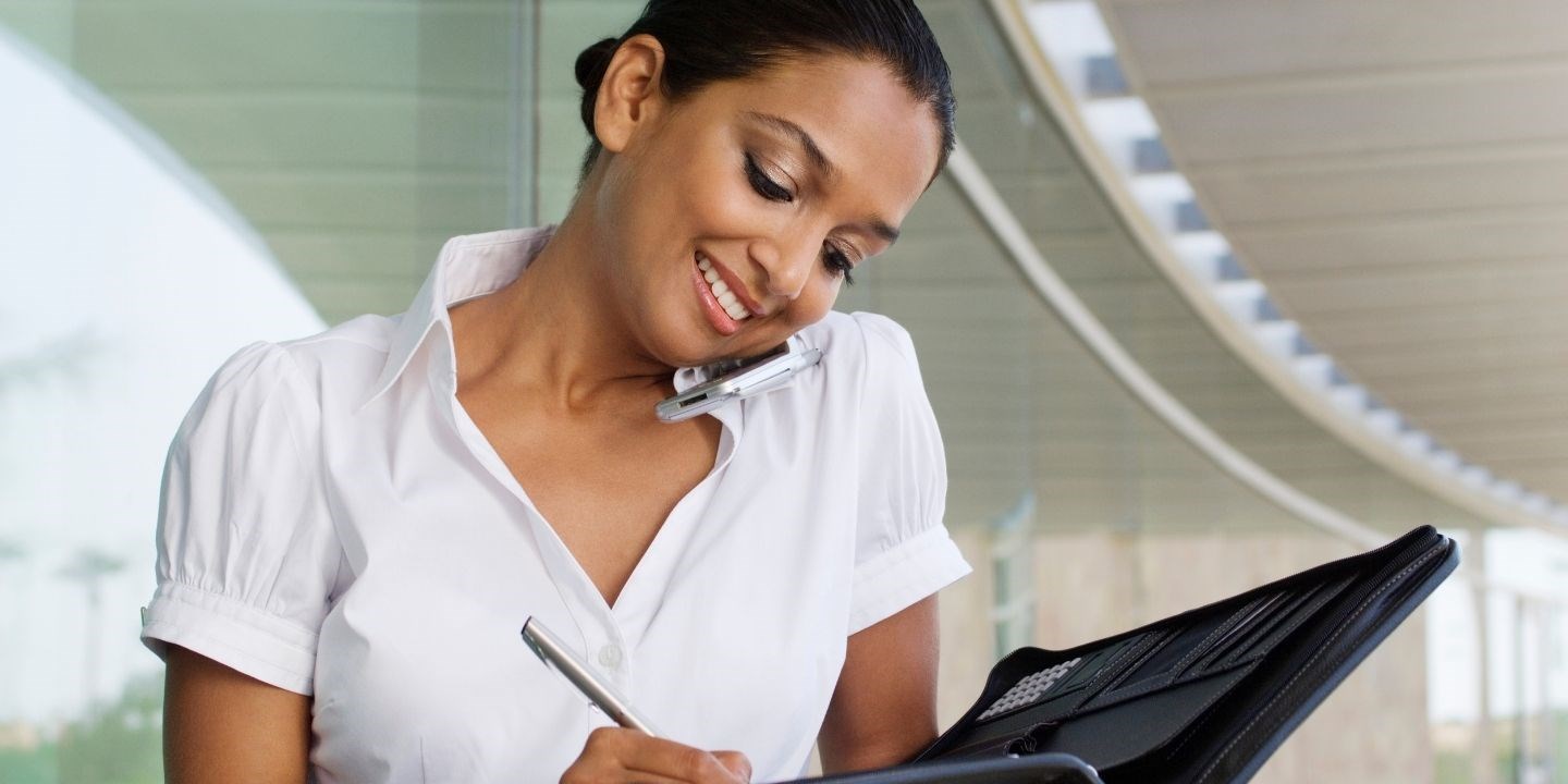 smiling woman writing in a planner